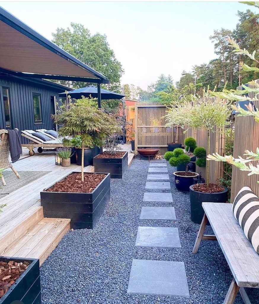 Modern garden path with stepping stones and black planters