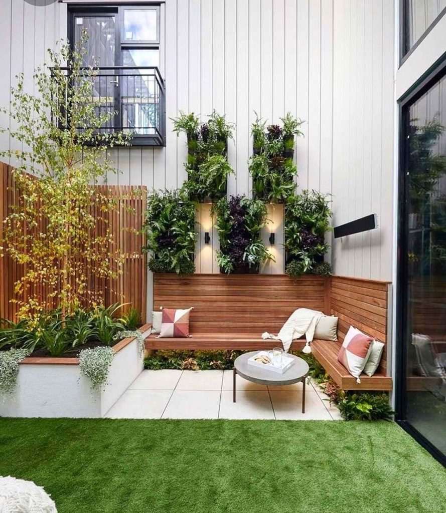Modern courtyard with vertical garden wooden bench and artificial grass
