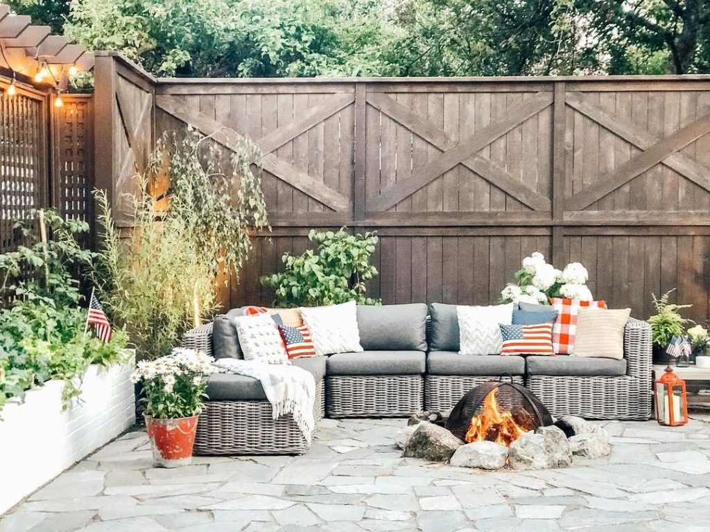 Outdoor patio with wicker furniture stone fire pit and patriotic decor