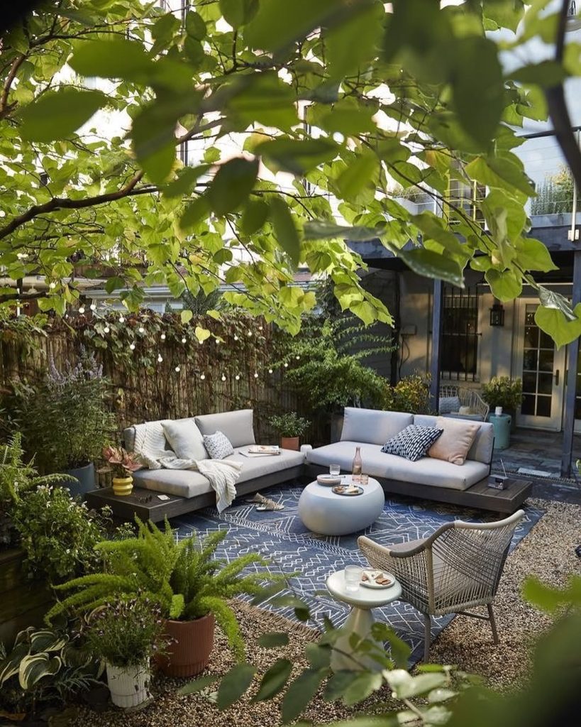 Garden lounge with tree canopy modern furniture and geometric rug