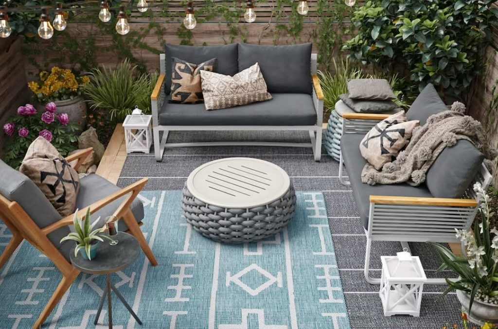Deck space with modern furniture blue rug and string lights