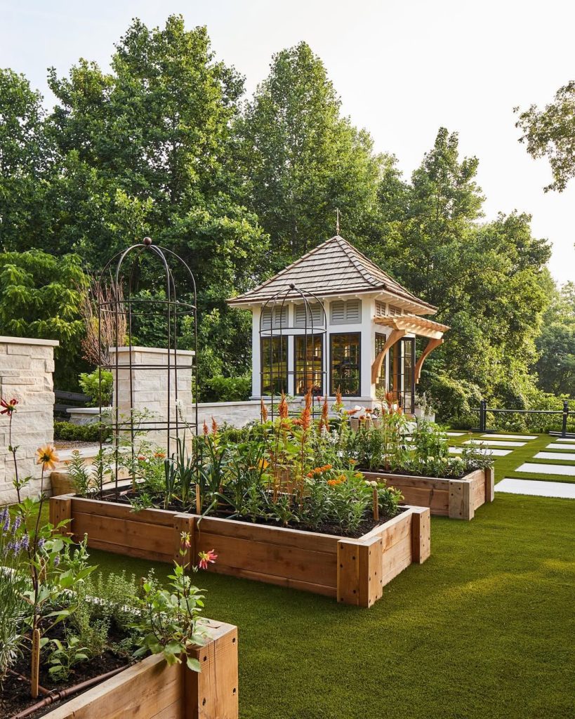 White gazebo with wooden raised beds and climbing structures