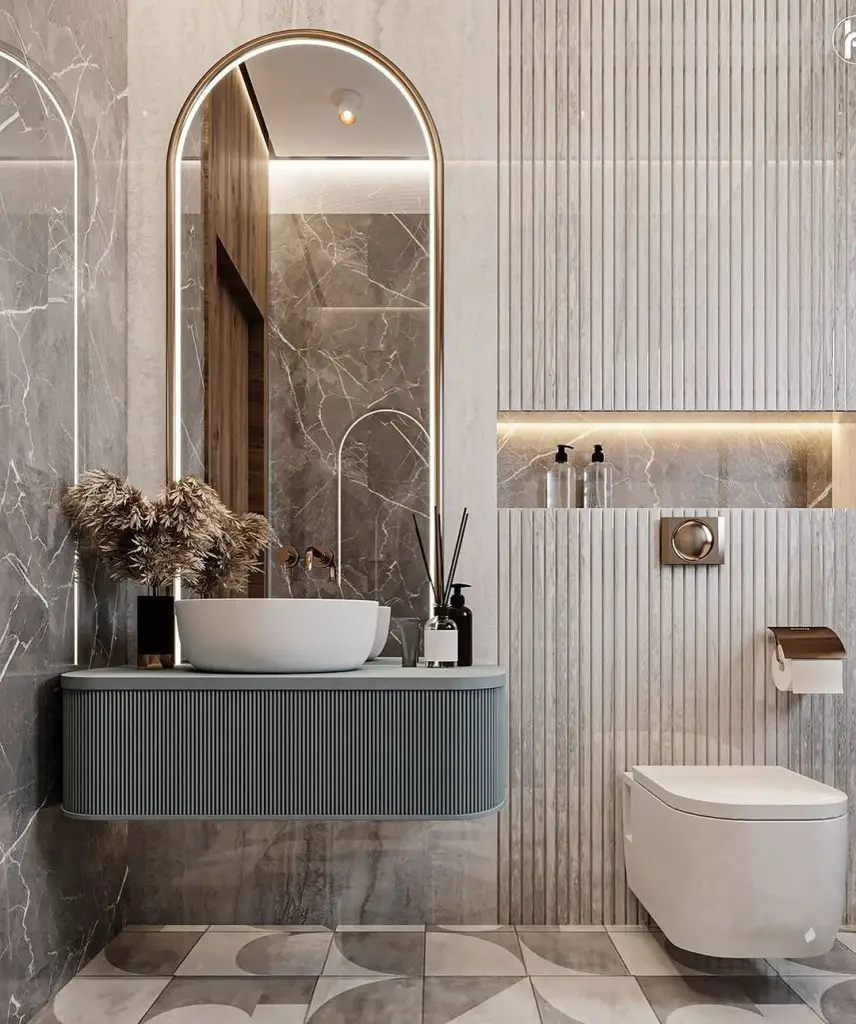 Contemporary powder room with arched mirror fluted vanity and marble accents
