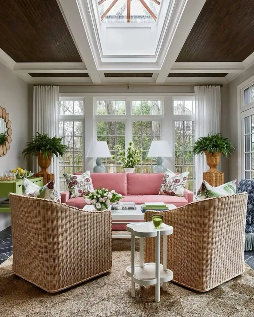 Elegant sunroom with coral sofa wicker chairs and coffered ceiling