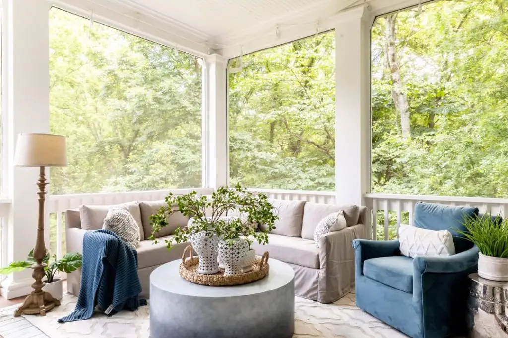 Modern porch with concrete table gray sofa and blue accent chair