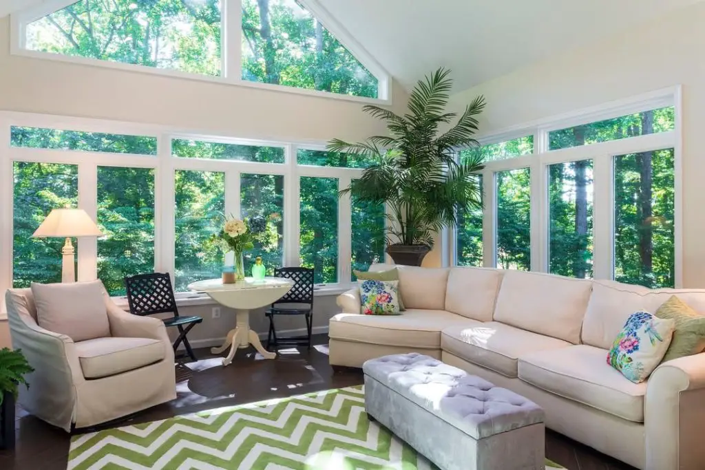 Bright sunroom with vaulted ceiling cream furniture and chevron rug