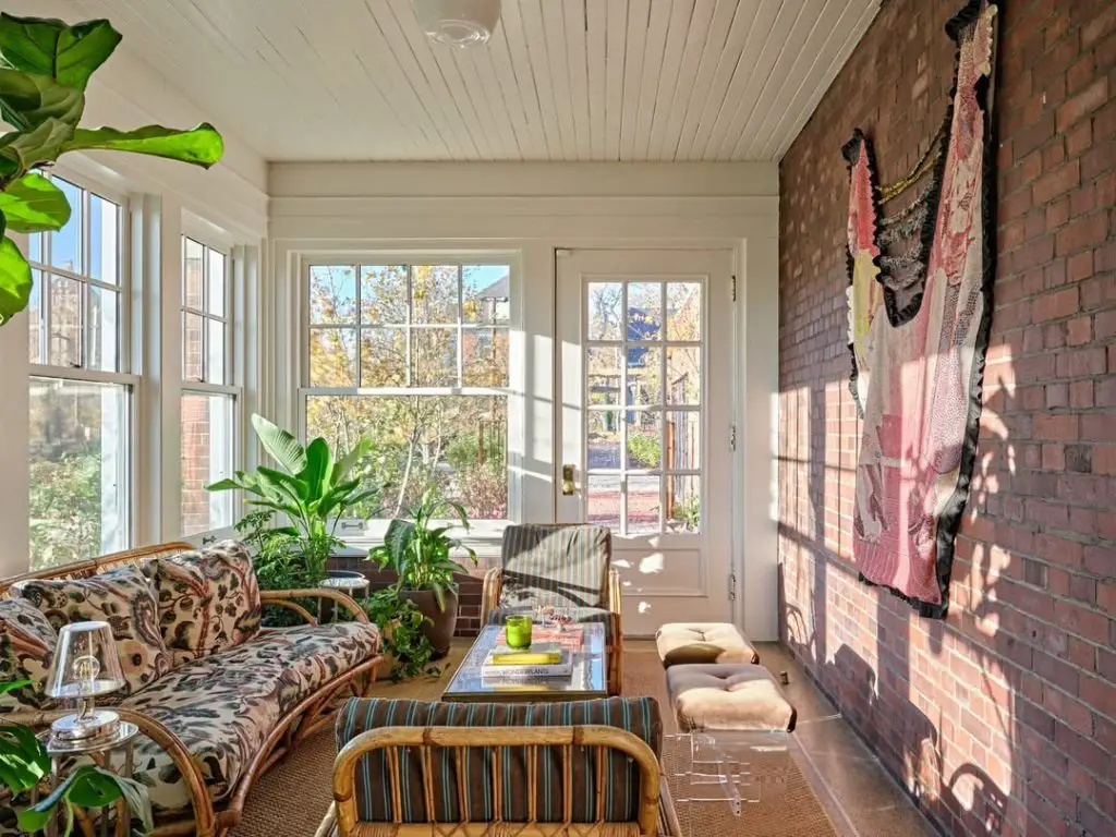 Sunroom with vintage furniture brick wall and tropical plants