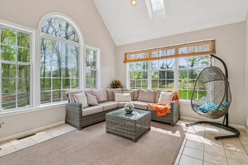 Modern sunroom with arched windows sectional sofa and hanging chair
