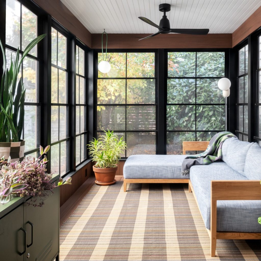 Minimalist sunroom with black frames sectional sofa and indoor plants