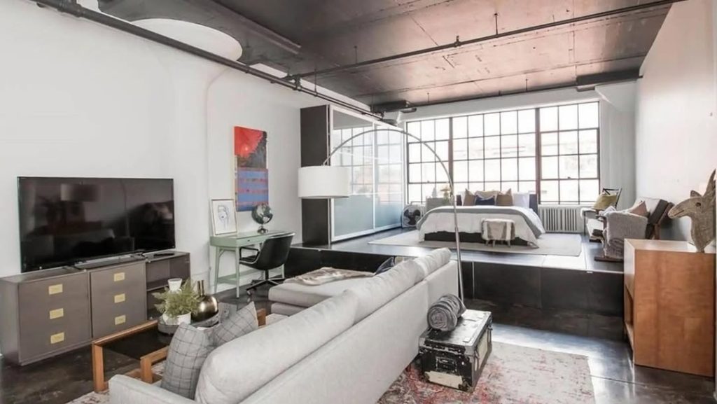 Industrial loft with raised platform bedroom