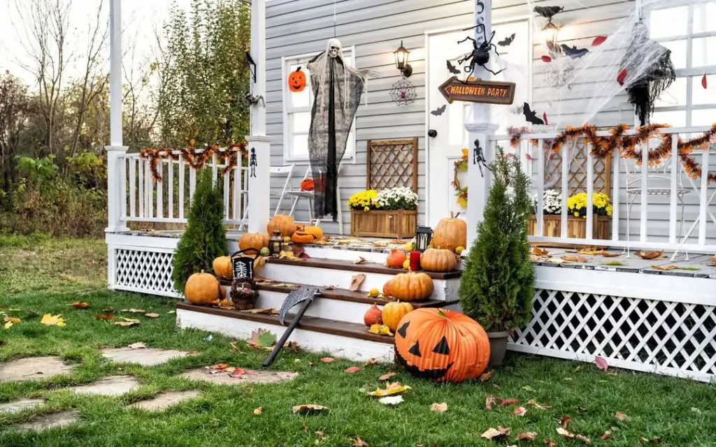 Halloween decorated front porch with pumpkins stairs and spooky decorations