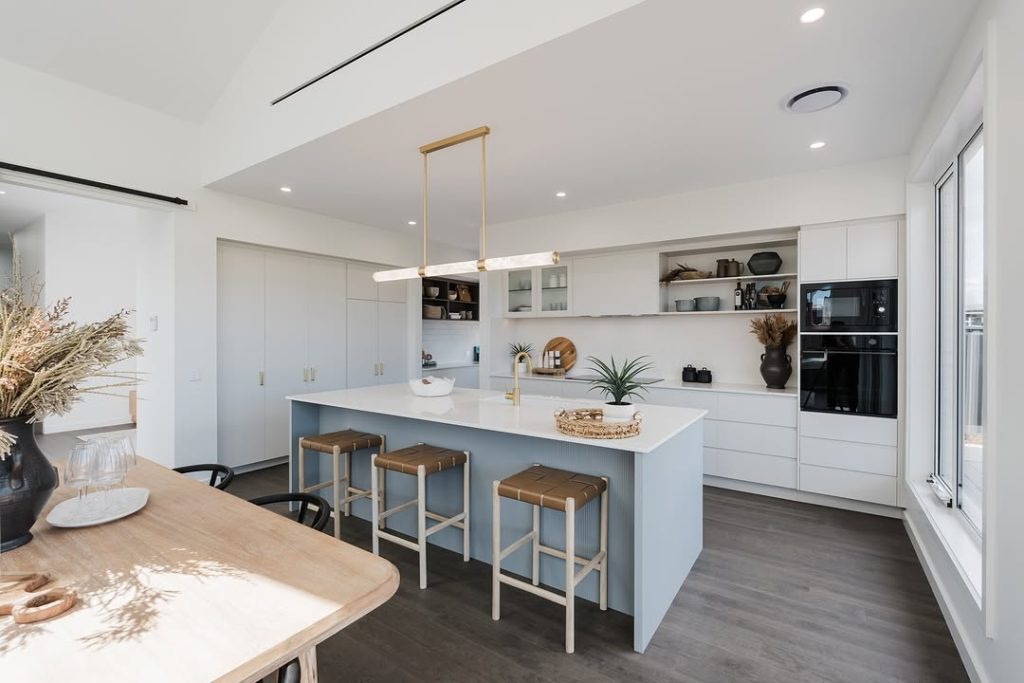 Minimalist kitchen with soft blue island and white cabinets