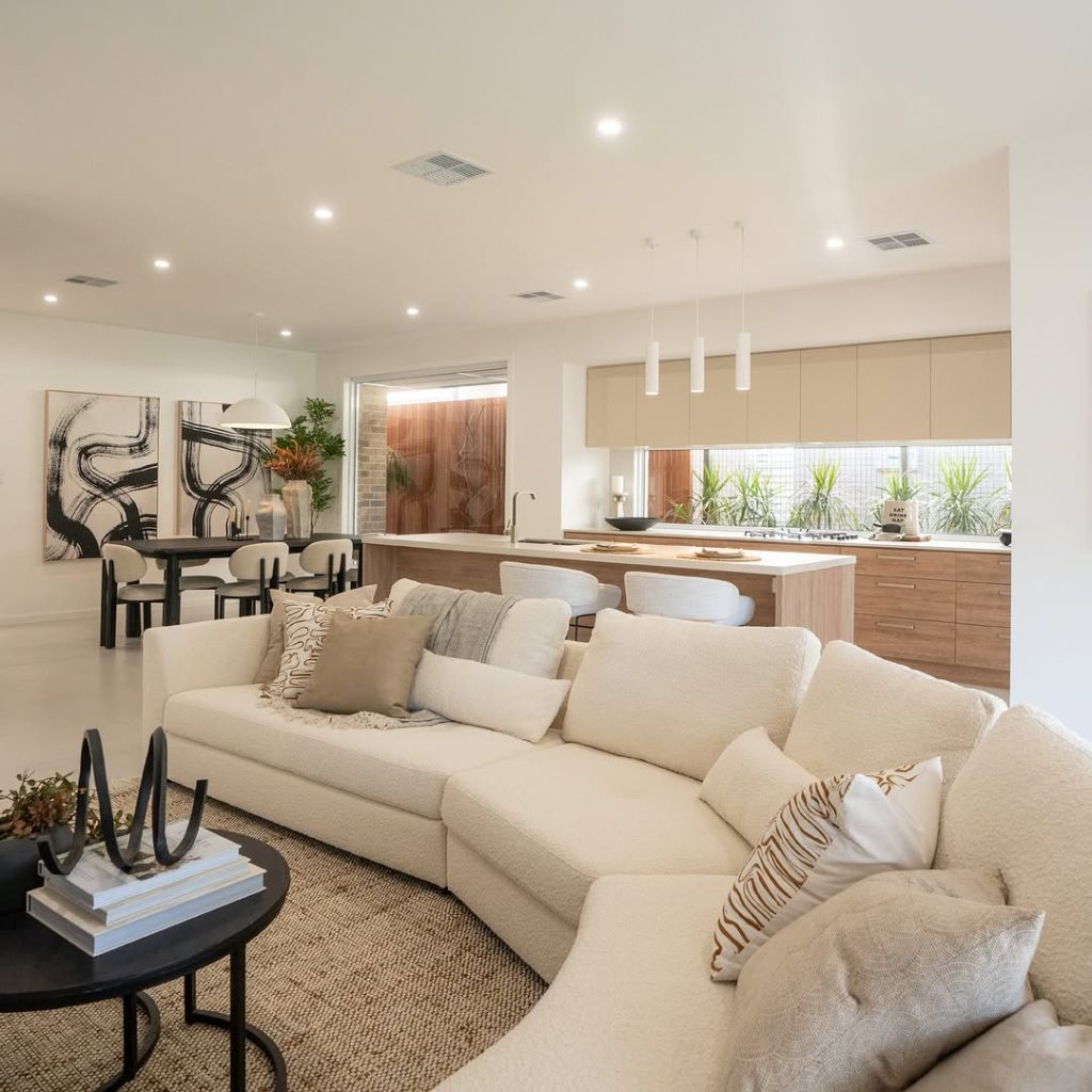 Open plan living space with neutral tones and wood kitchen