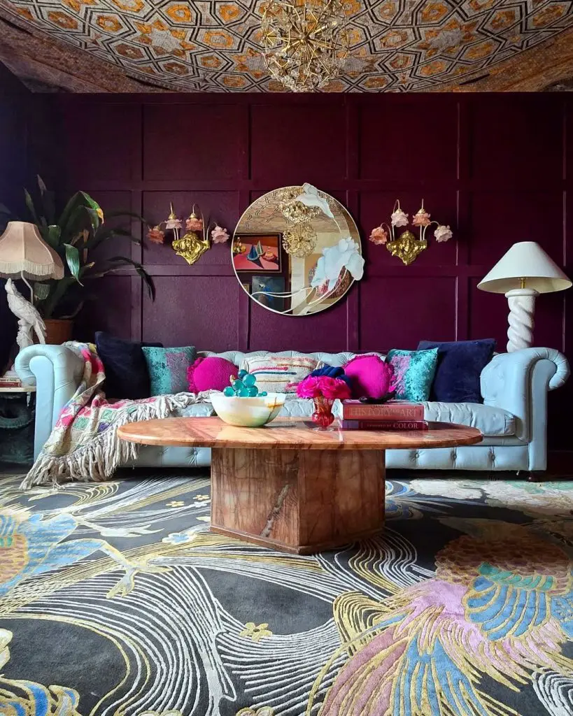 White sofa with burgundy walls, geometric ceiling, colorful patterned rug