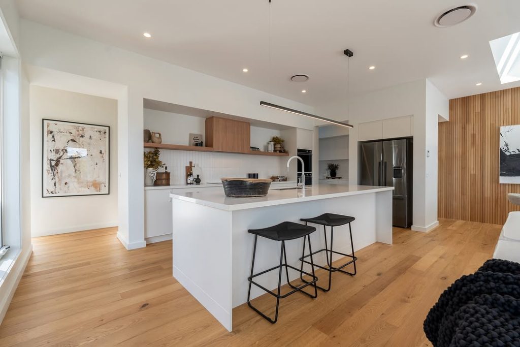 White kitchen with wood accents and black bar stools