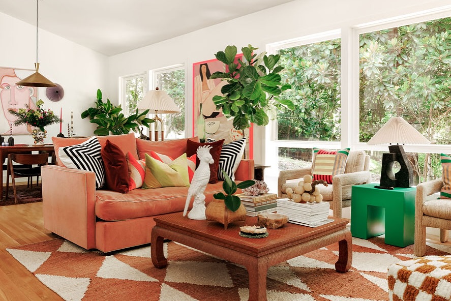 Coral sectional sofa with geometric rug and striped accent pillows