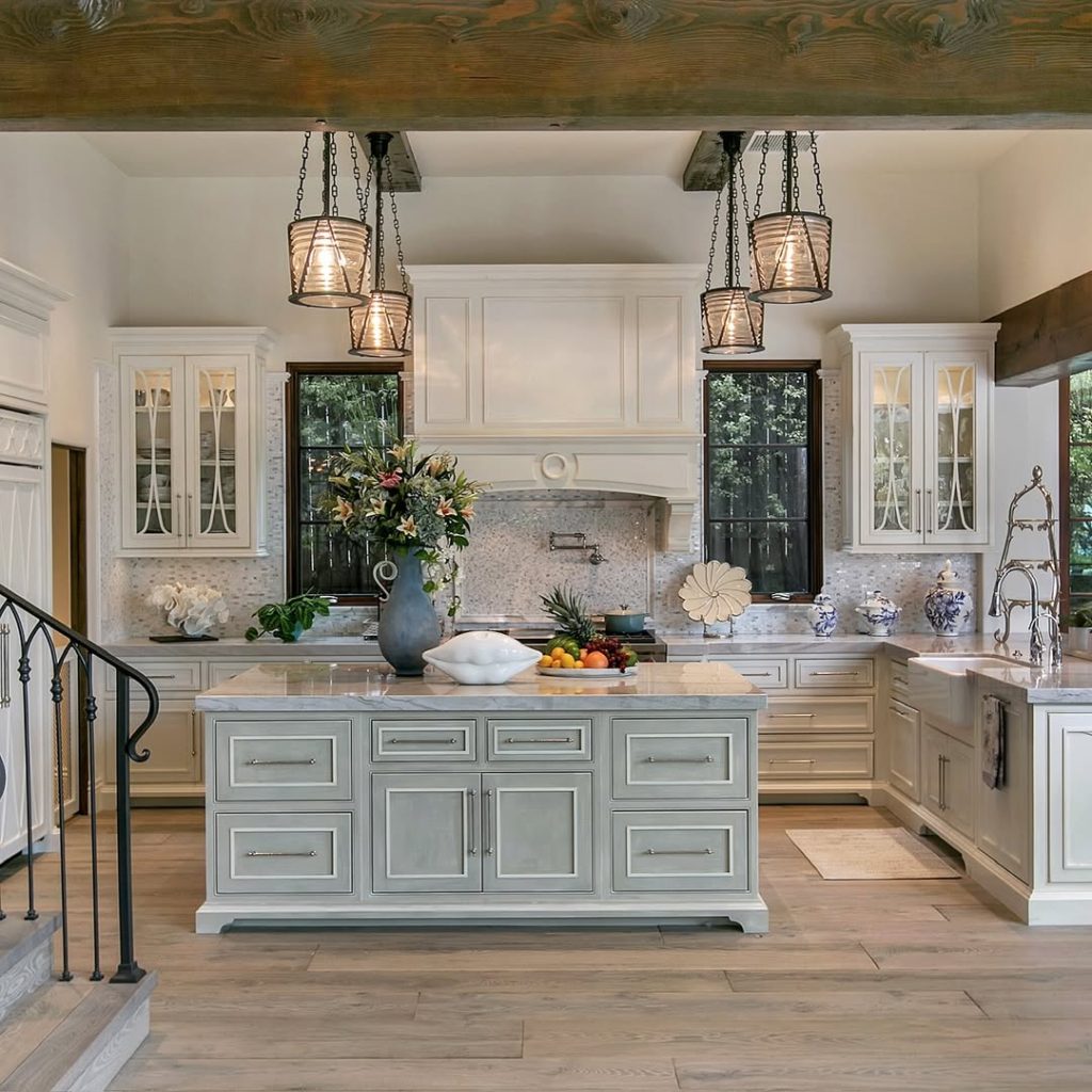 Coastal farmhouse kitchen with wood beams, sage island, white cabinets