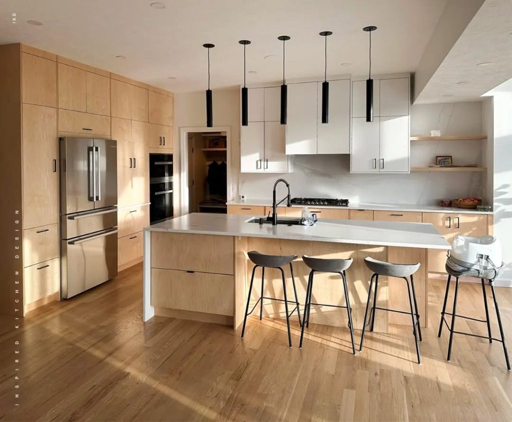 Modern kitchen with black cylinder pendant lights, wood cabinets, white uppers, curved stools