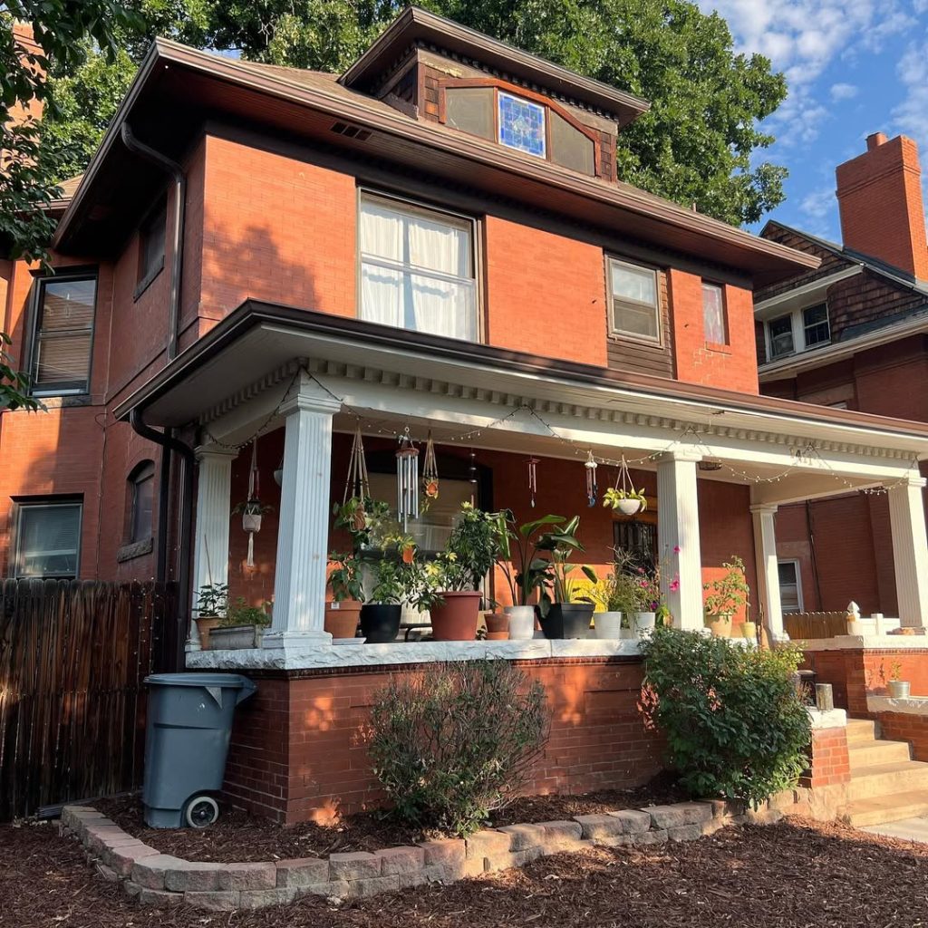 Orange brick craftsman with white column porch