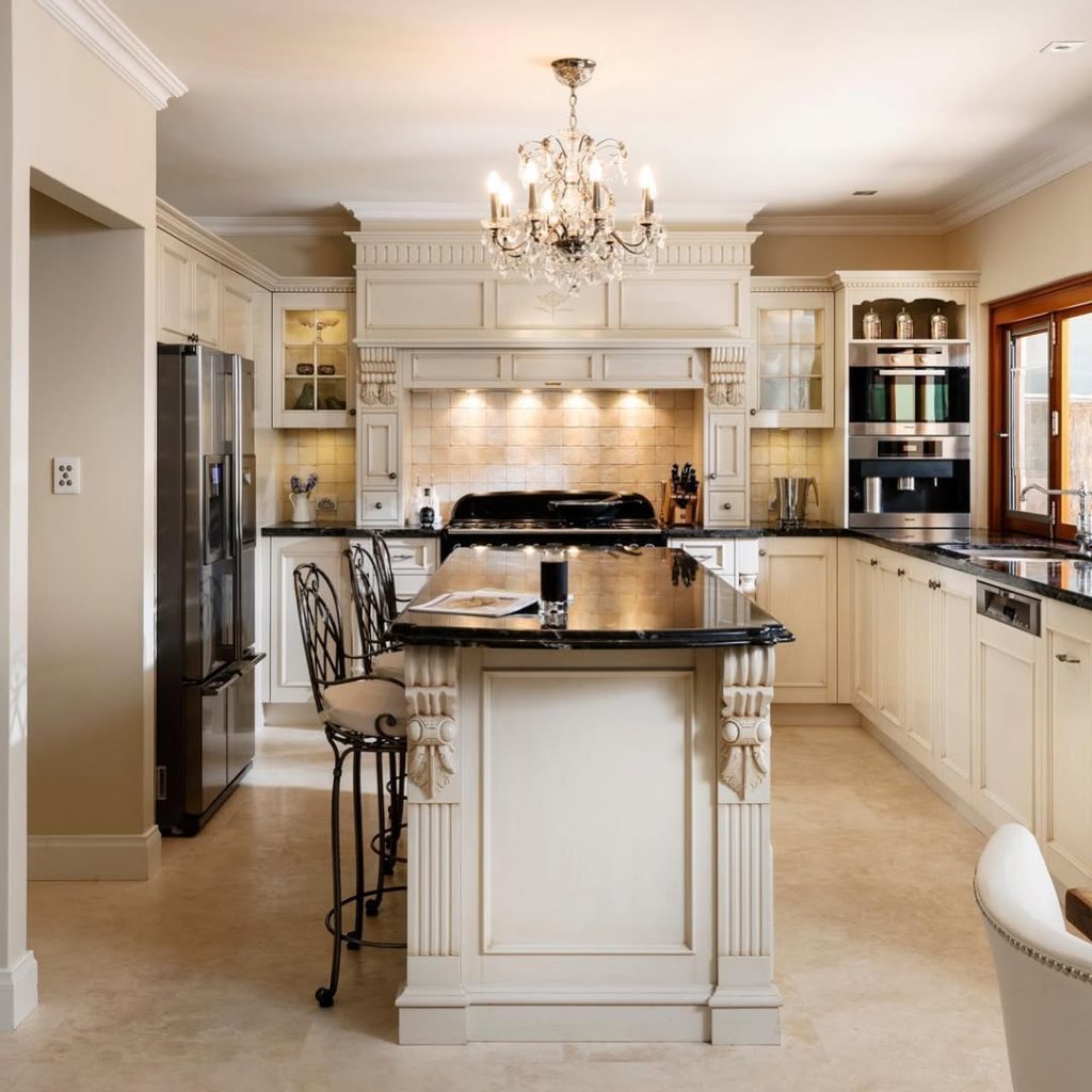 Traditional kitchen with crystal chandelier, granite island, cream cabinets