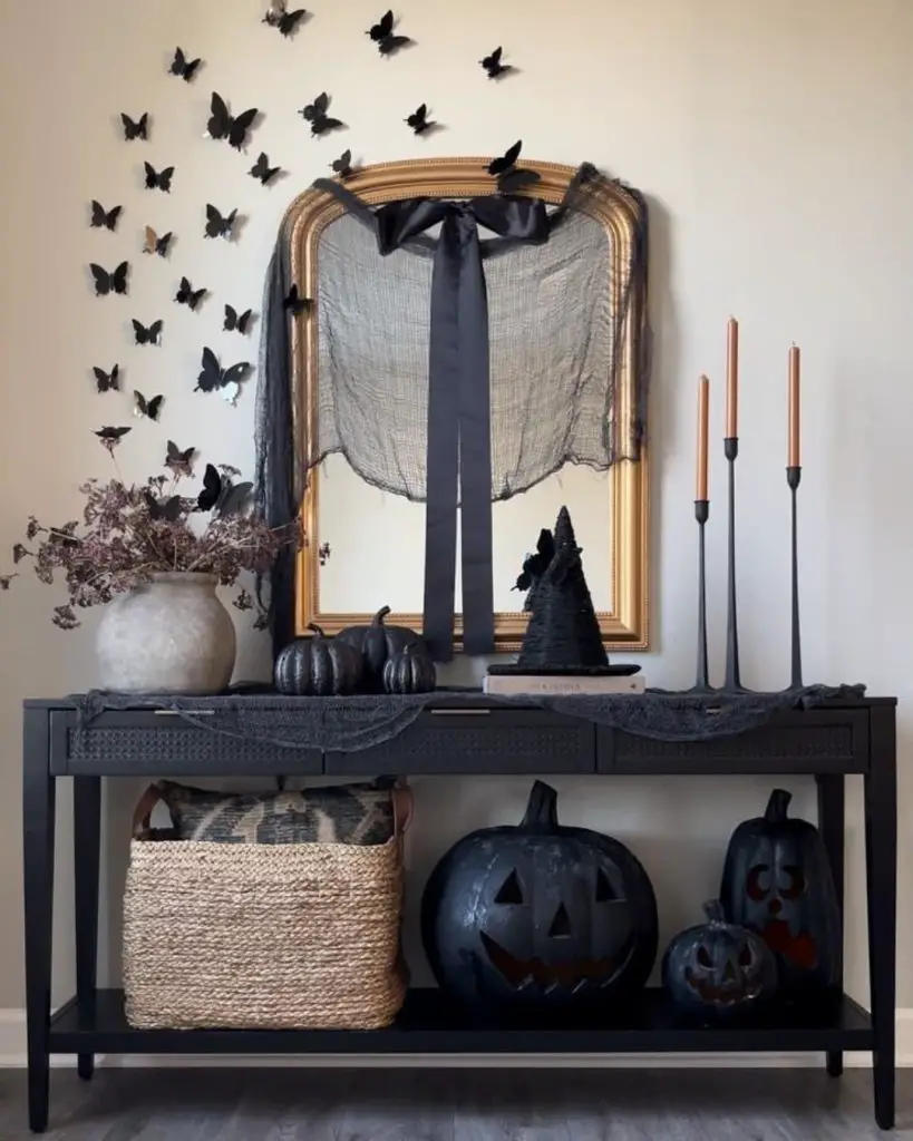 Dark elegant console table with butterflies mirror and black Halloween decor