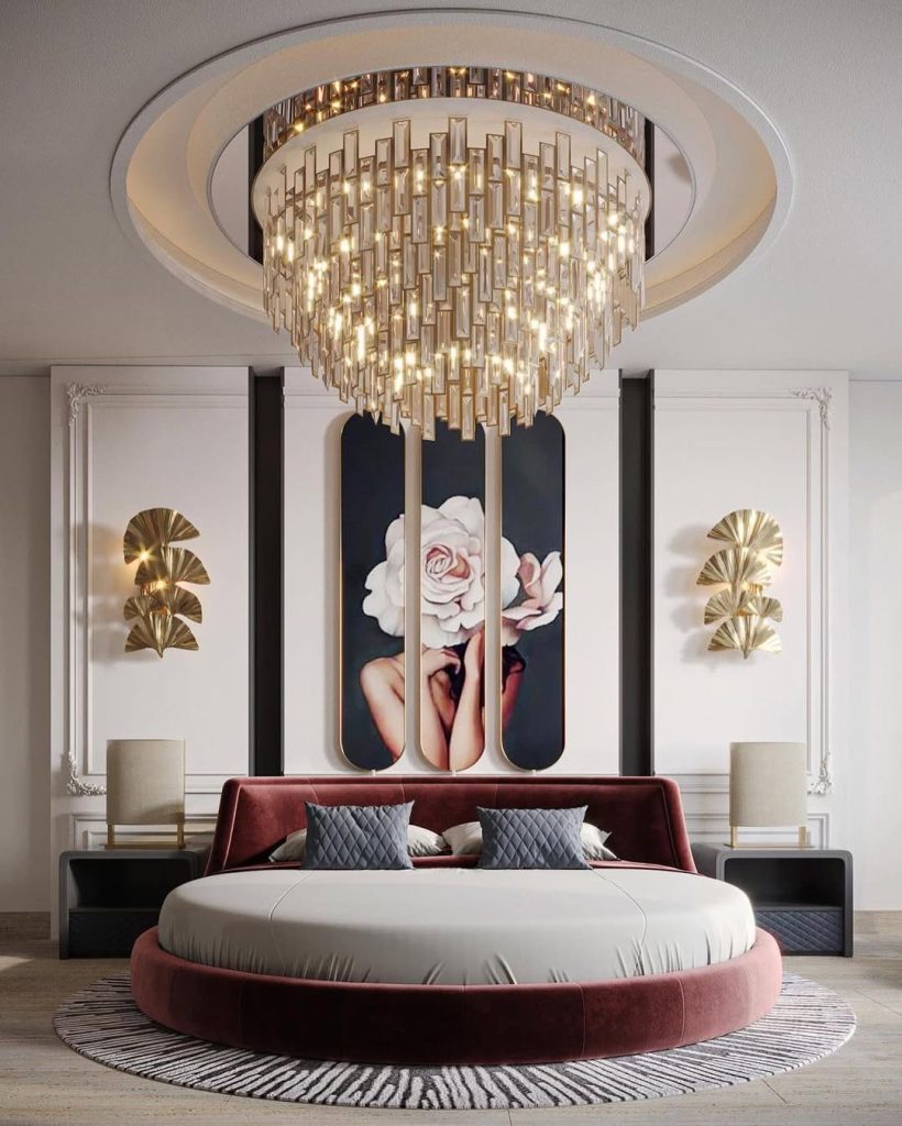 Luxurious round bed with dramatic chandelier and floral artwork