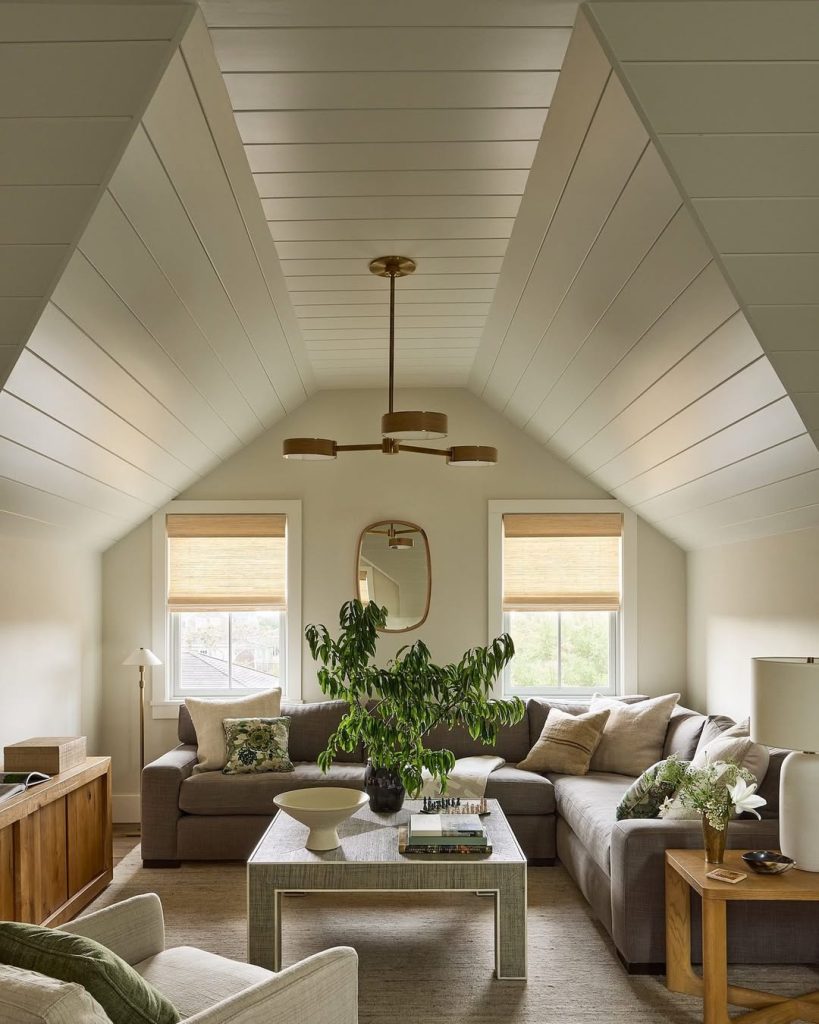 Attic living room with sloped ceiling, white shiplap, sectional sofa, and natural light