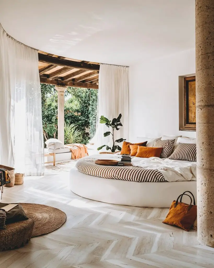 Circular floating bed with white curtains and terrace access