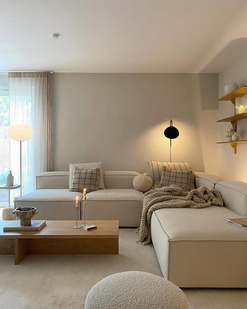 Neutral sectional sofa with floating shelves and ambient lighting design