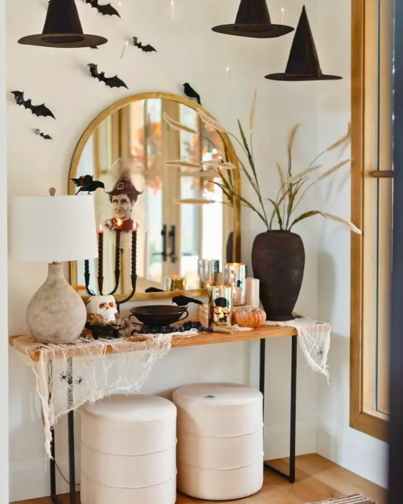 Console table with floating witch hats bats and magical Halloween styling