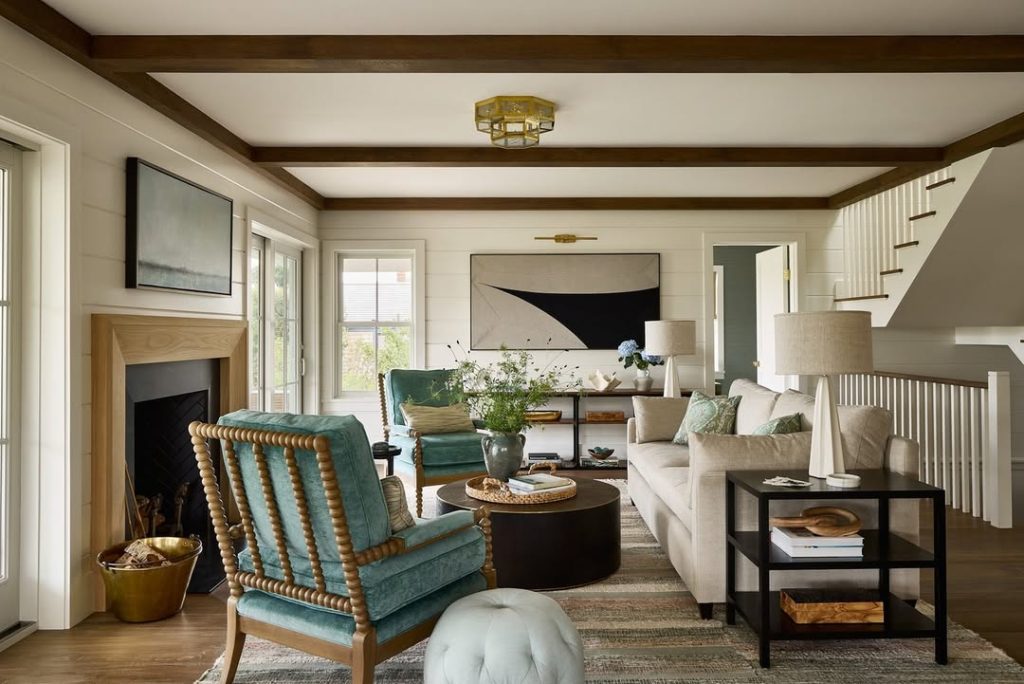 Traditional living room with exposed beams, turquoise accent chair, neutral sofa, and classic styling