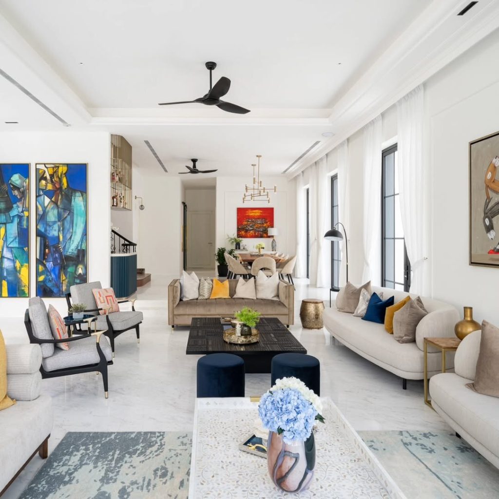 Modern white living room with colorful artwork and neutral furniture