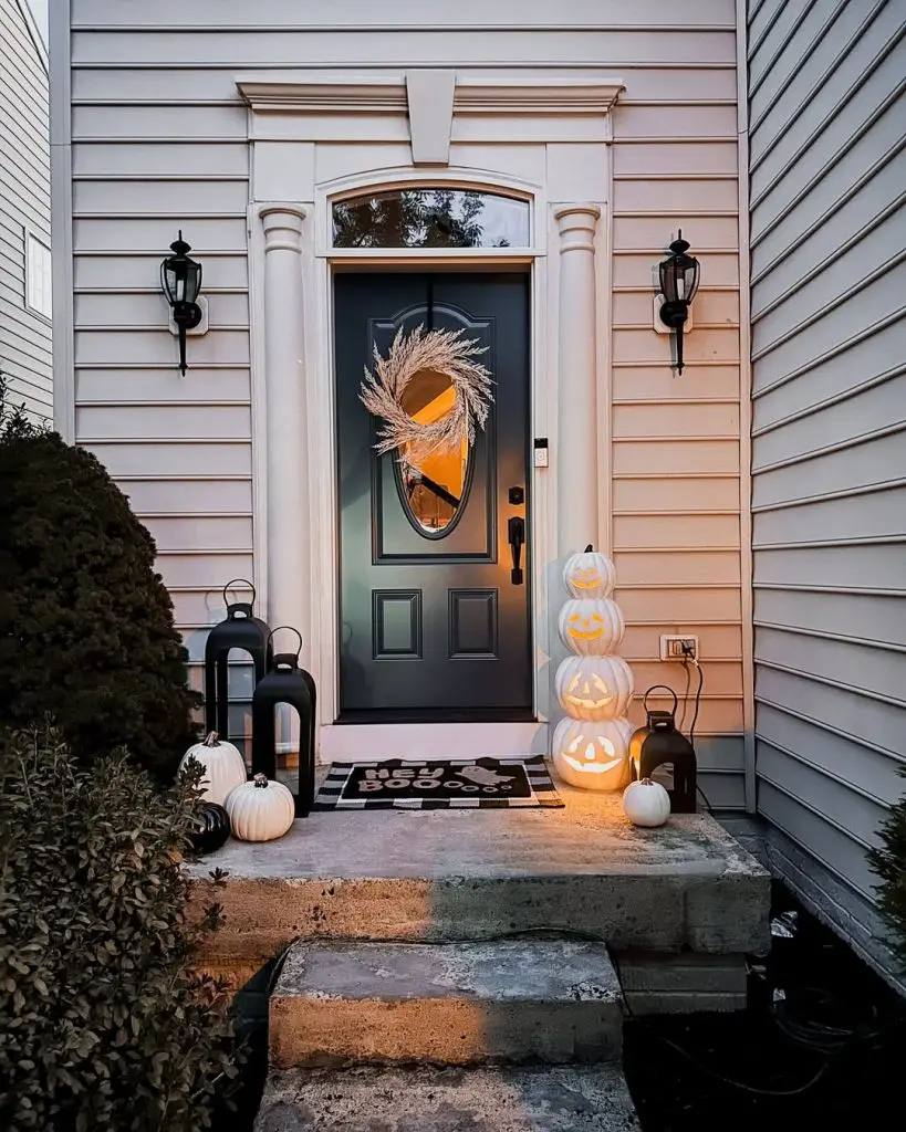 Front door decorated with white pumpkins and wheat wreath for Halloween