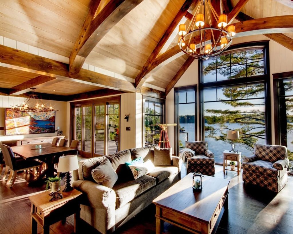 Rustic living room with exposed beams lake views plaid chairs