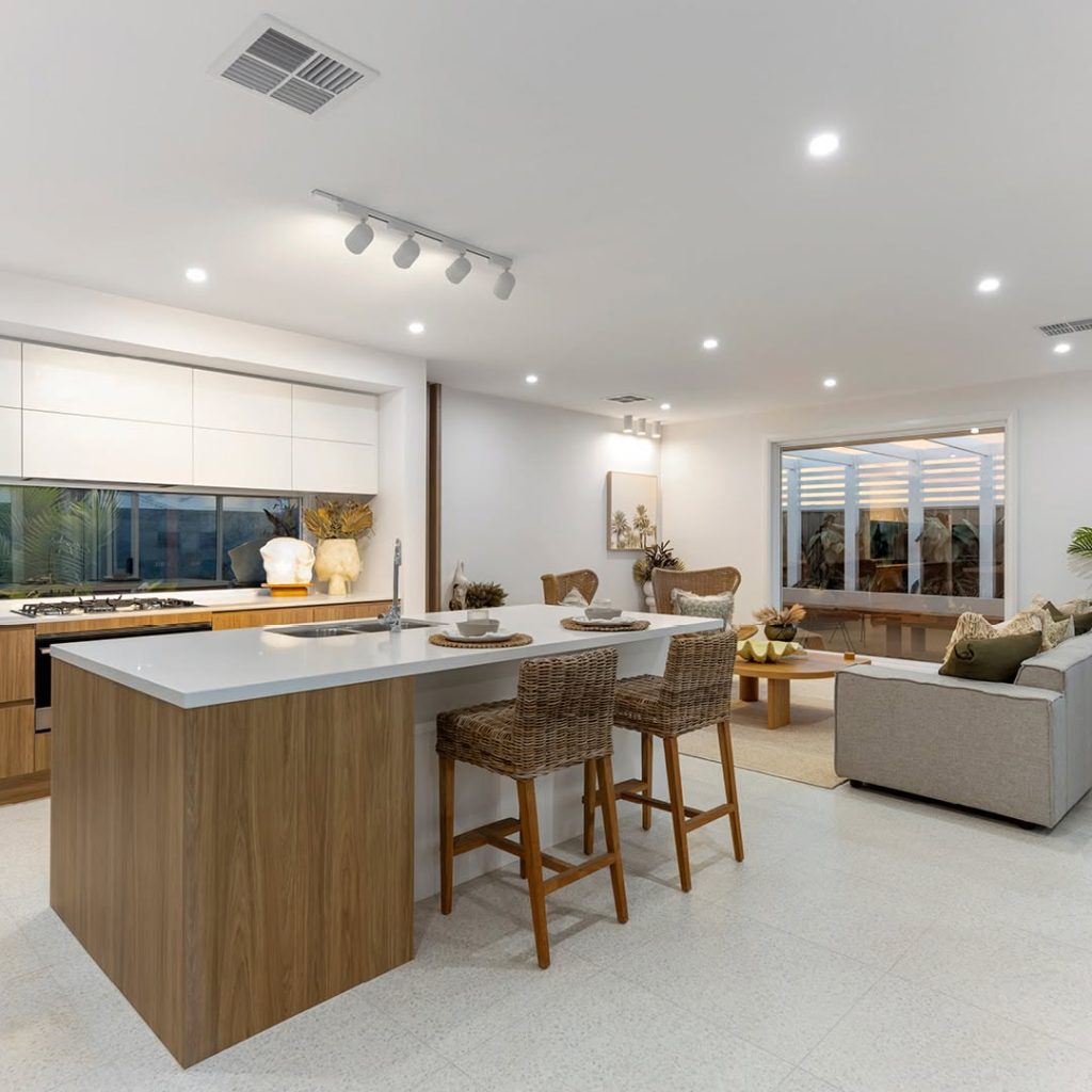 Open kitchen with wood cabinets, stone counters, and woven bar stools