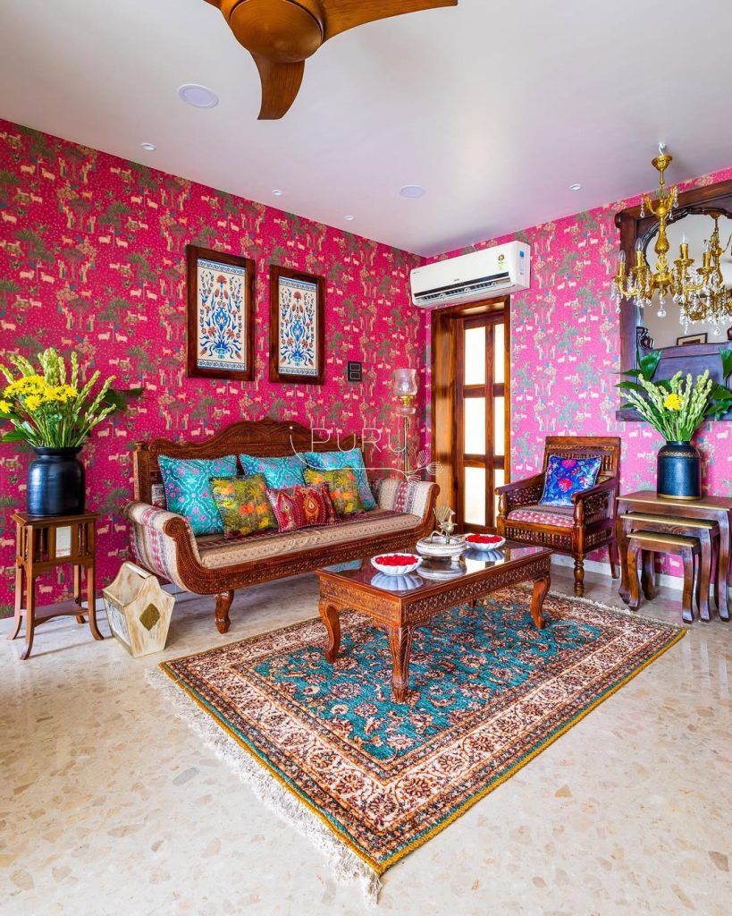 Bold pink wallpaper with traditional wooden furniture and Persian rugs