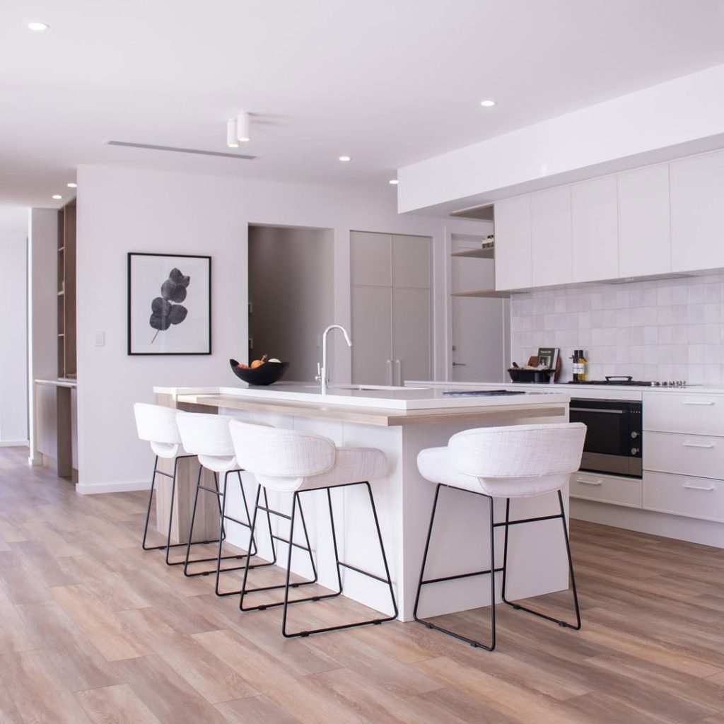 White minimalist kitchen with waterfall island and clean lines