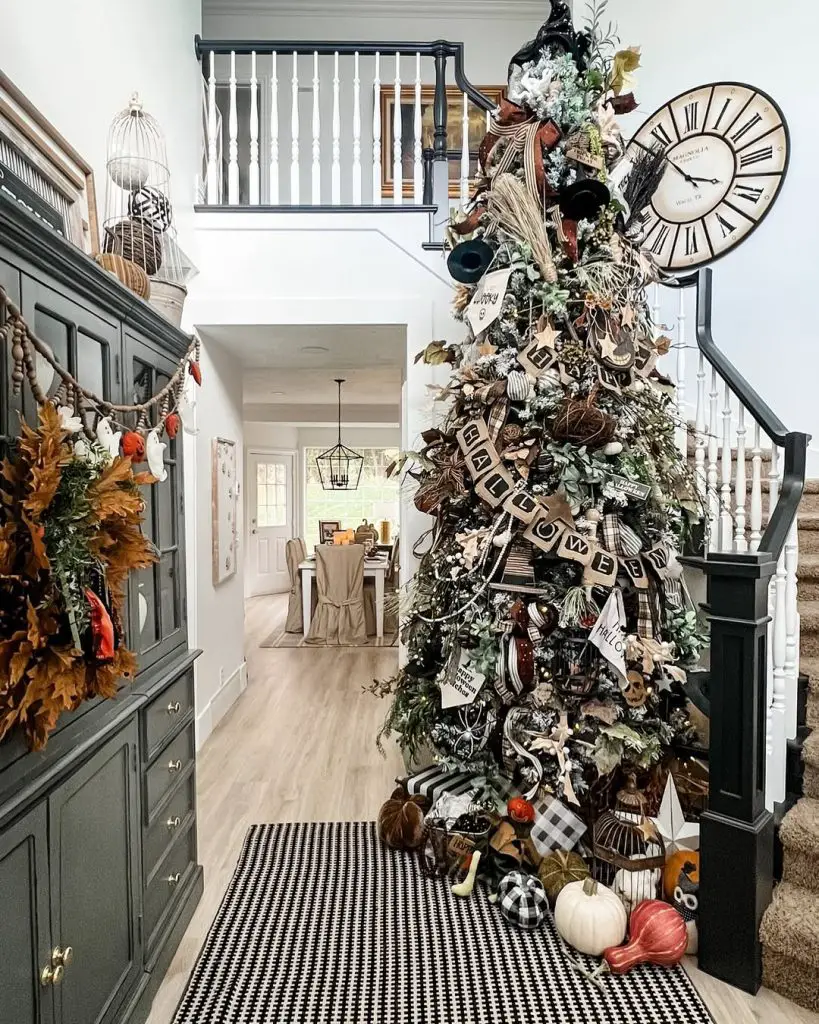 Large Halloween tree with clocks banners and black decorations in entryway