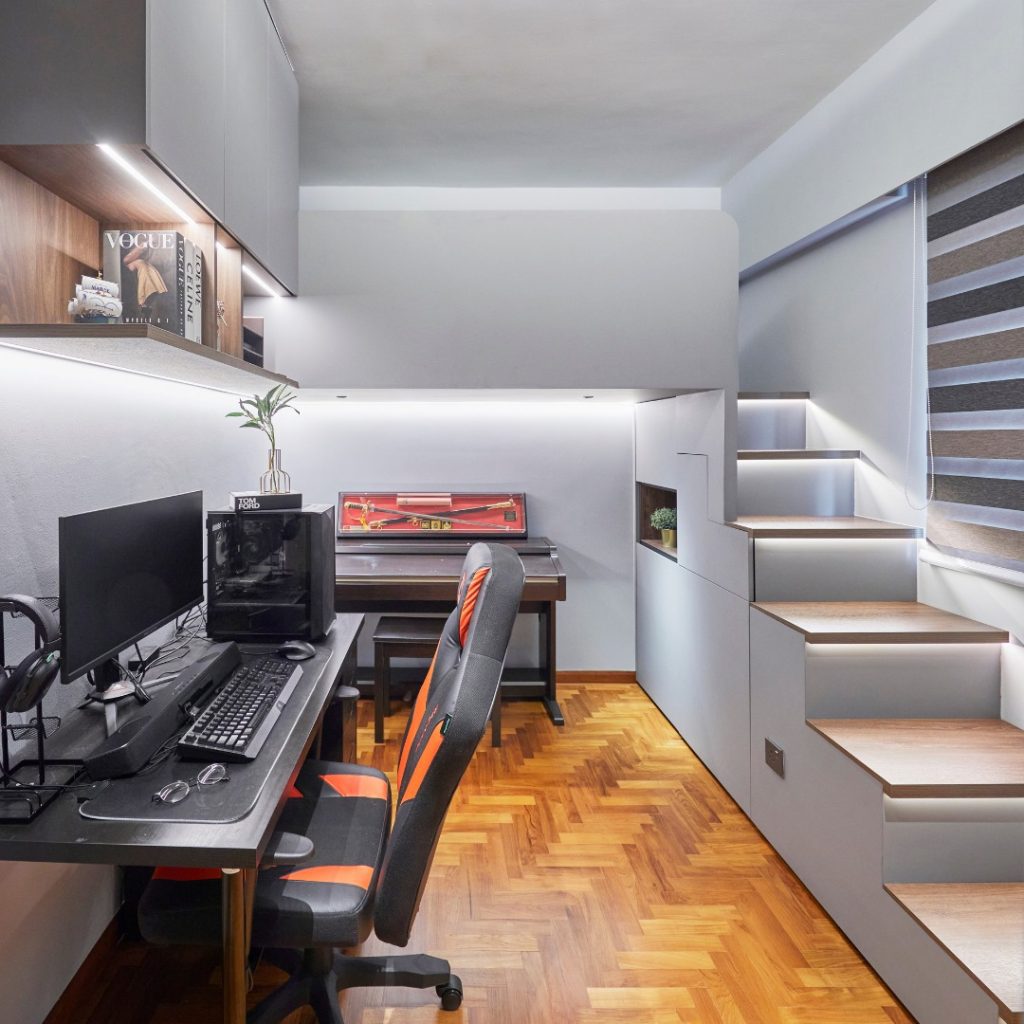 Under-stair gaming station with orange accents and monitors