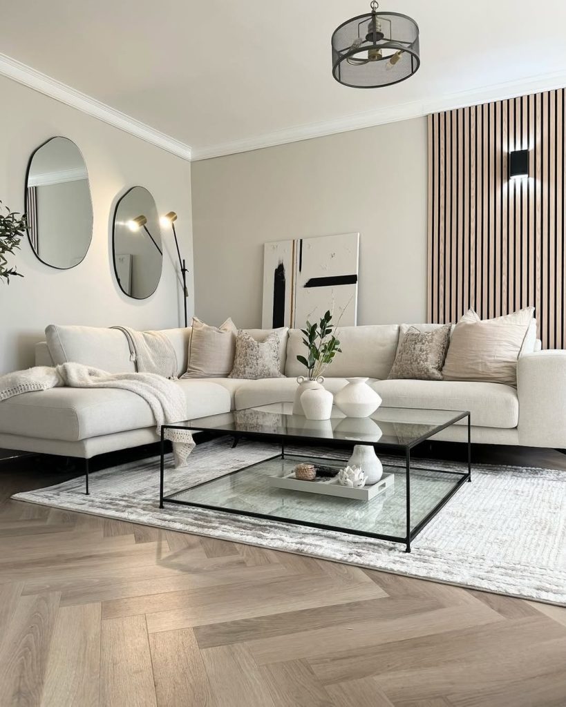 Neutral sectional sofa with striped accent wall and glass coffee table