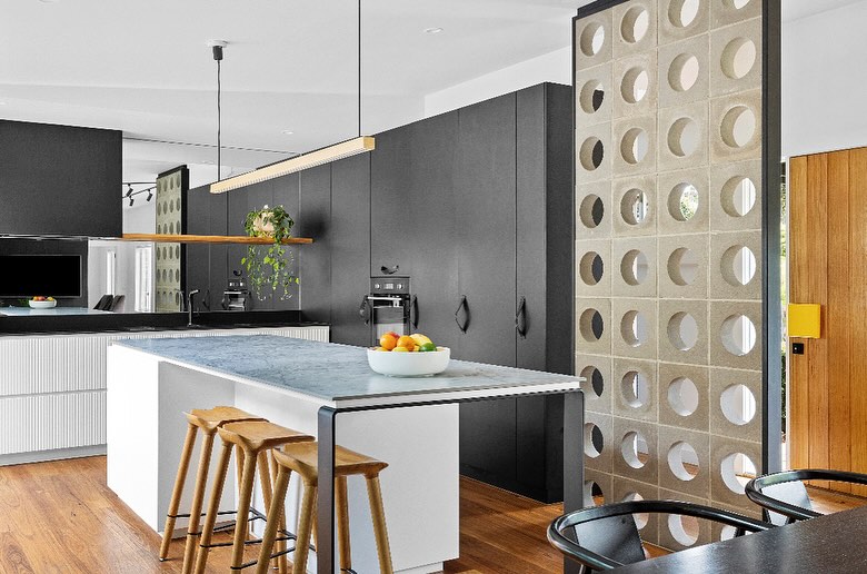 Modern kitchen with perforated concrete walls and blue marble island
