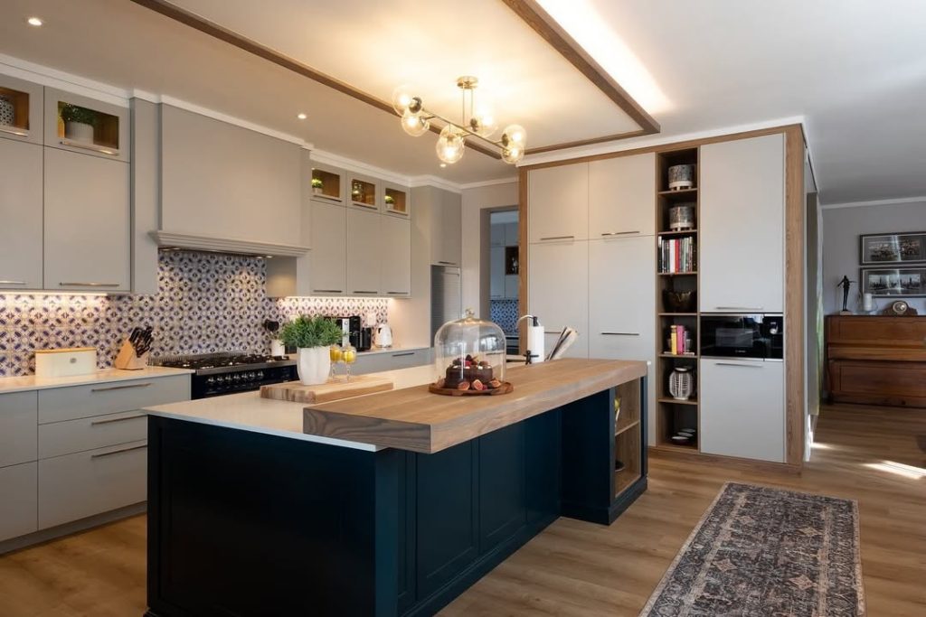 Kitchen with navy island, geometric backsplash, and exposed ceiling beams