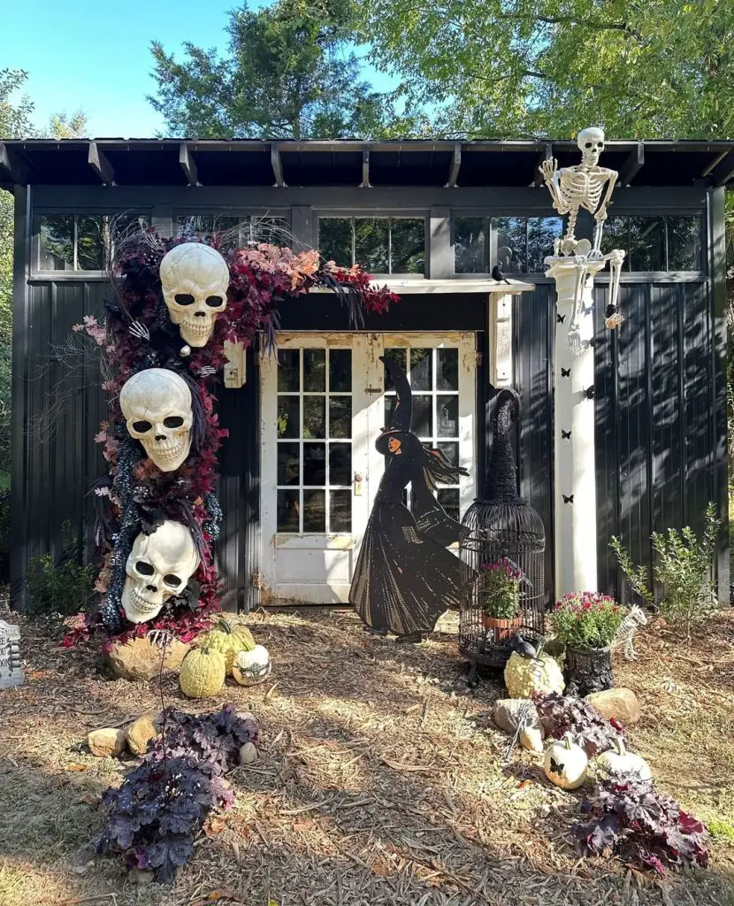 Outdoor Halloween display with skulls witch figure and autumn decorations