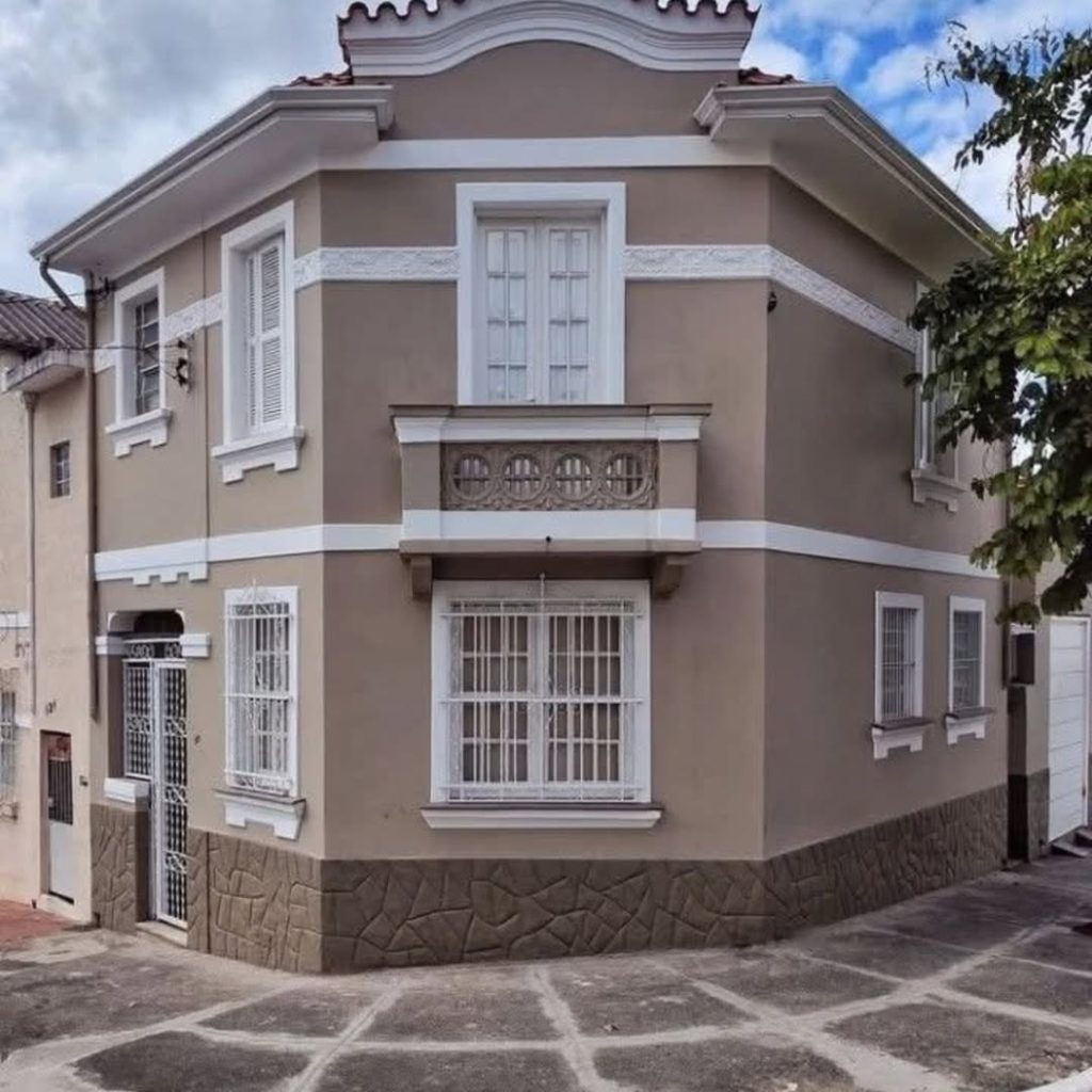 Taupe corner house with decorative balcony trim