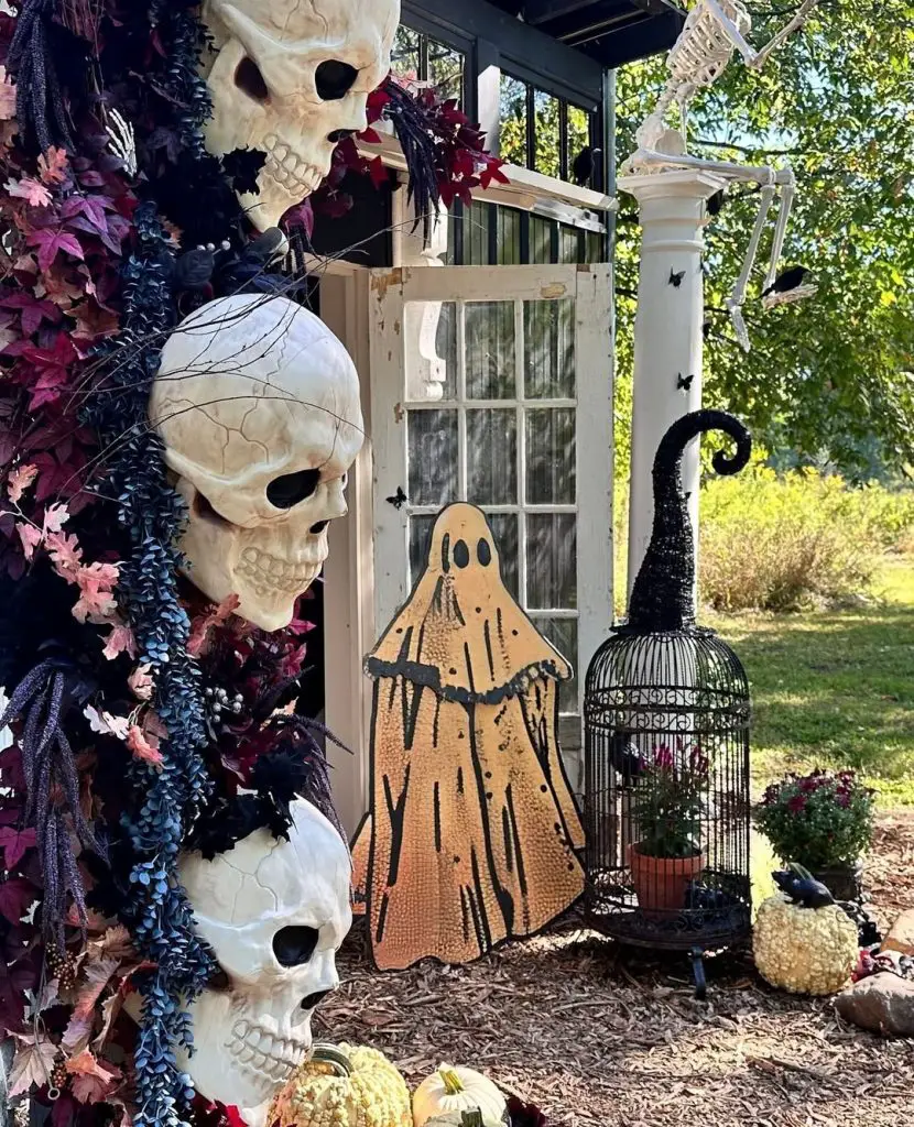 Rustic Halloween porch decoration with skulls pumpkins and autumn foliage