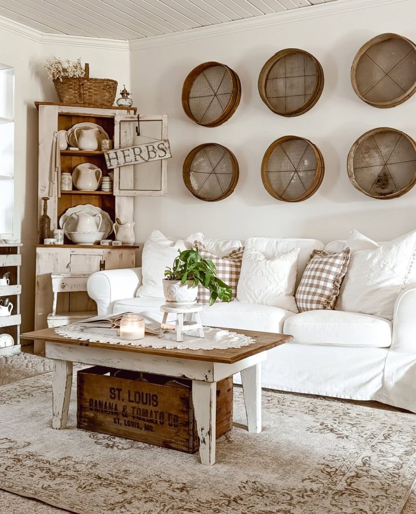 White farmhouse living room with wooden basket wall art, vintage cupboard, and checkered throw pillows