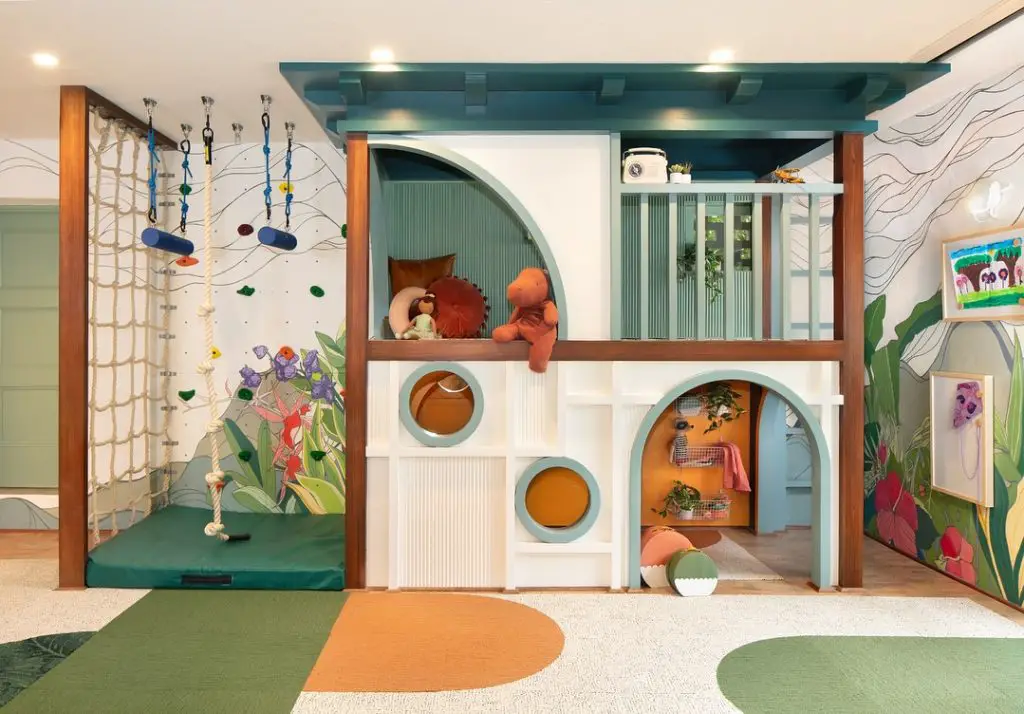 Jungle themed playroom with climbing nets and tropical wall murals