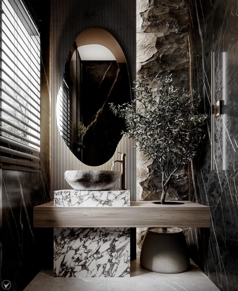 Dramatic bathroom with natural stone walls and curved mirror