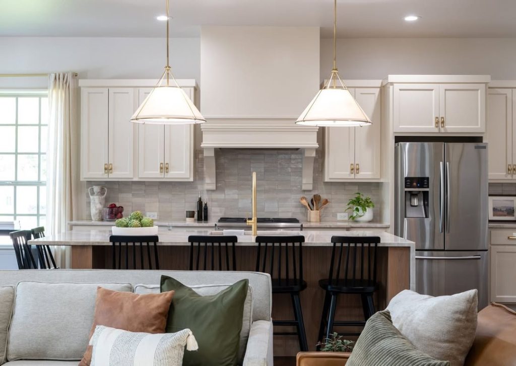 Traditional white kitchen with brass hardware and geometric pendants