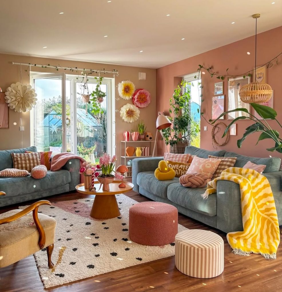 Sage sectional sofa against peach walls with yellow accents and paper flowers